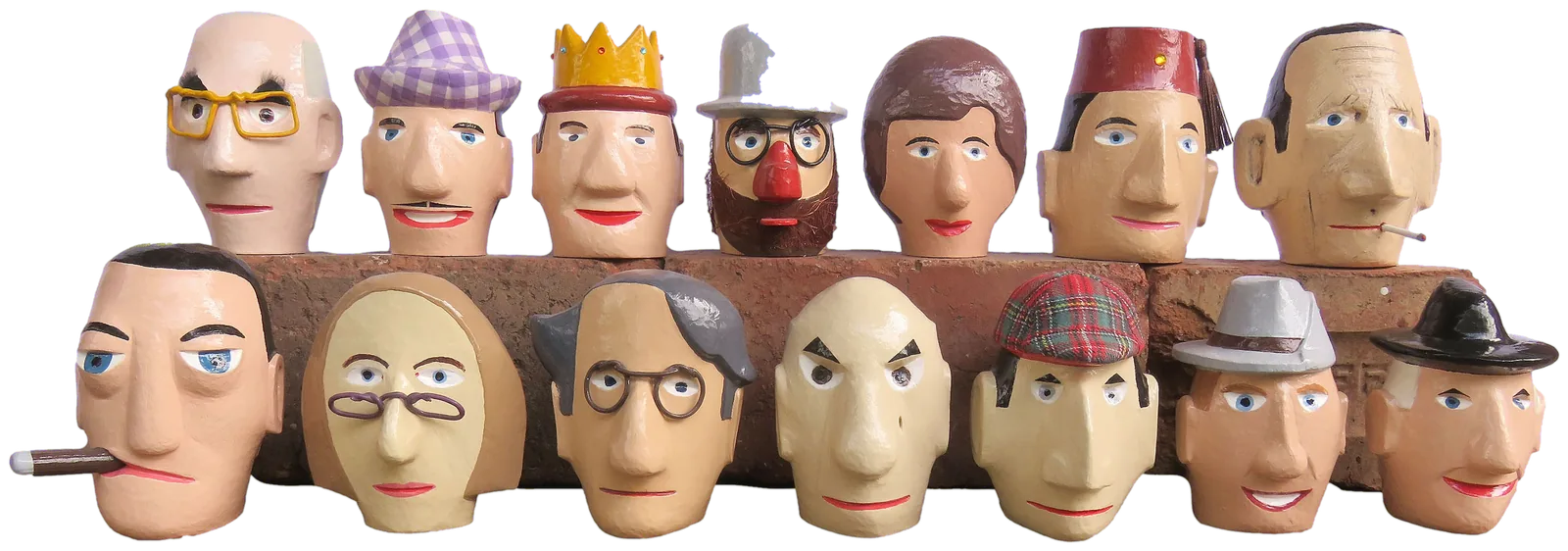 Fourteen small carved and painted wooden heads in two rows on old bricks: among them a bald newsreader in yellow glasses, a man in a lilac gingham hat, a king in a gold crown, a professor with a red nose and a grey bowler, a woman with a brown bob, and a magician in a red fez.
