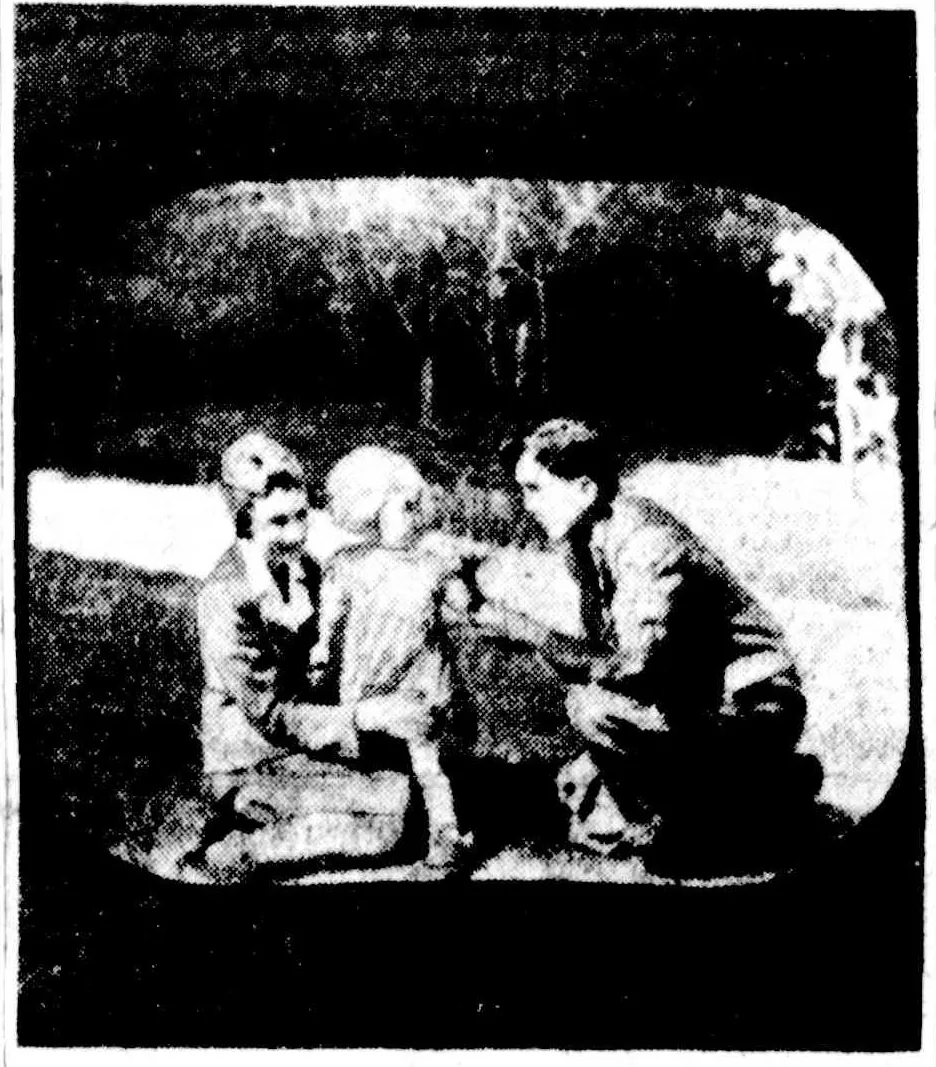 A newspaper halftone of a television screen with rounded corners: on it, a woman, a small child and a kneeling man on a lawn, trees behind.